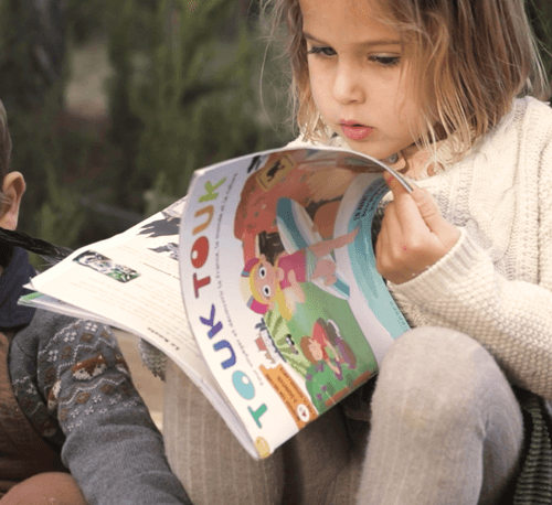 Enfant lisant un magazine Touk Touk